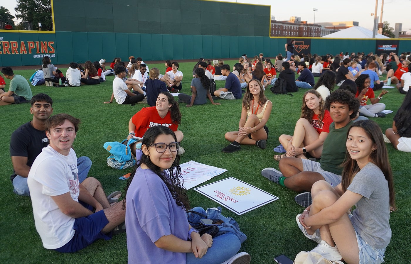 students sitting in a circle turned to smile at the camera