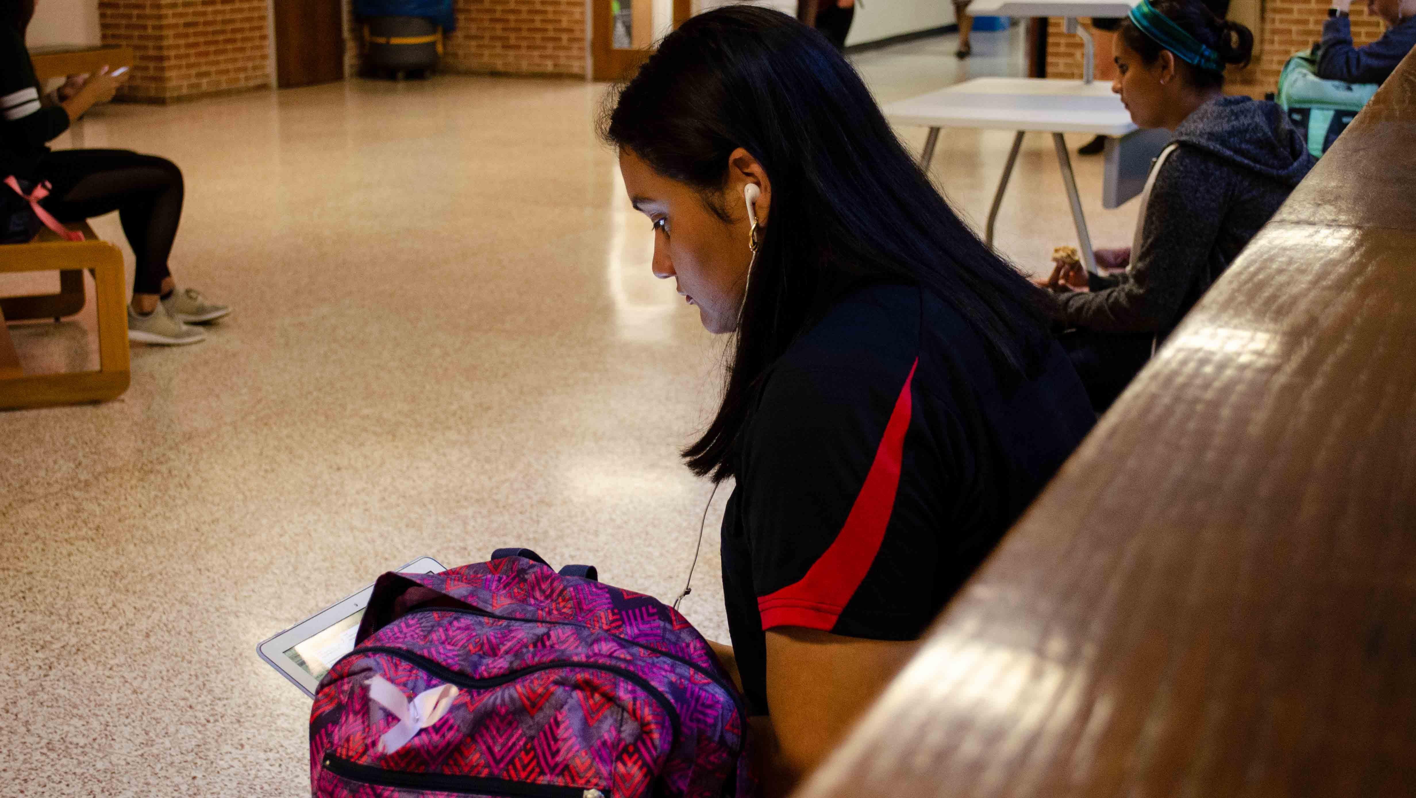 Marlen Cruz sitting in hallway waiting for class to begin