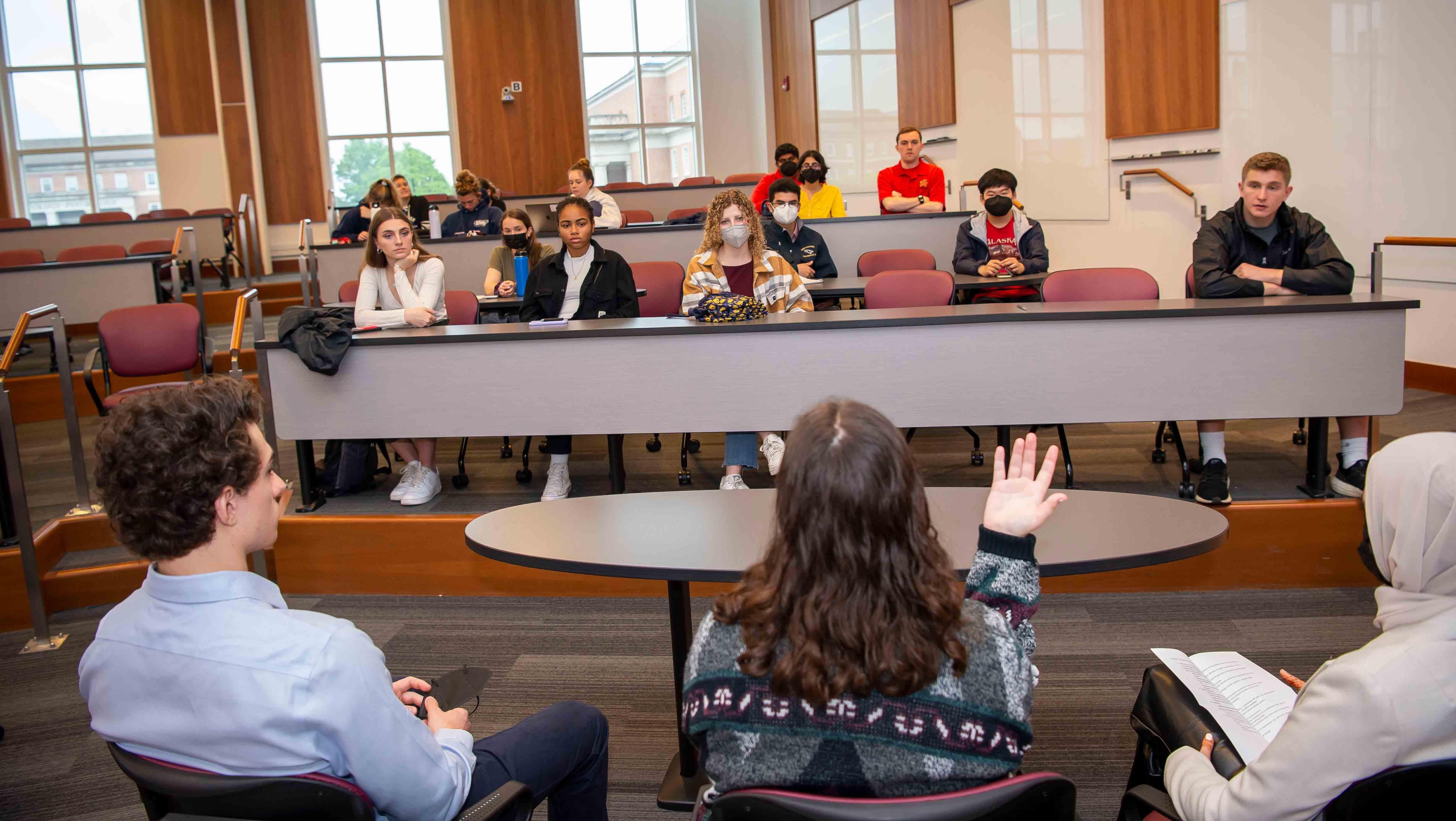 Students listen to a panel of three students talking about a topic