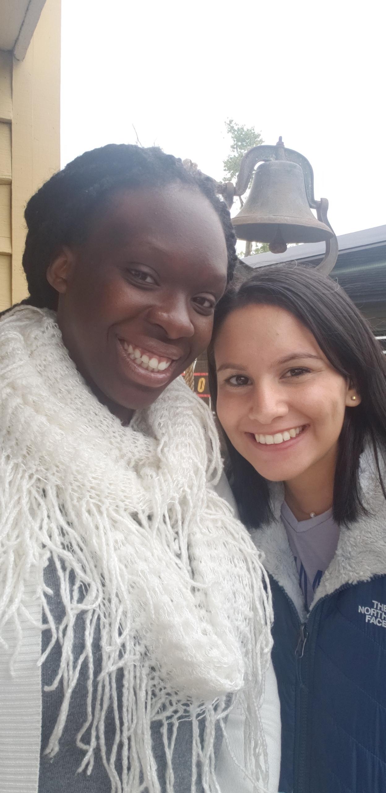 two students smile in front of liberty bell