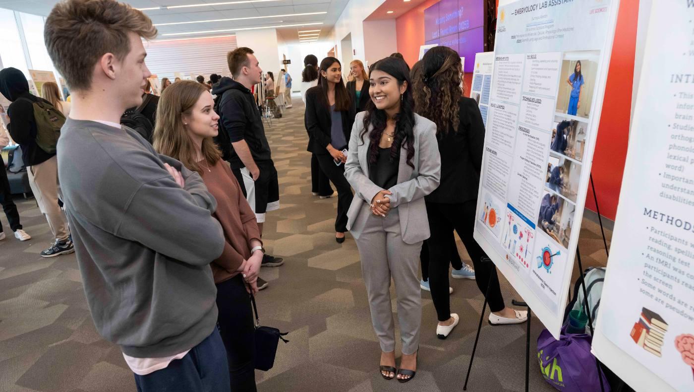 students discuss poster