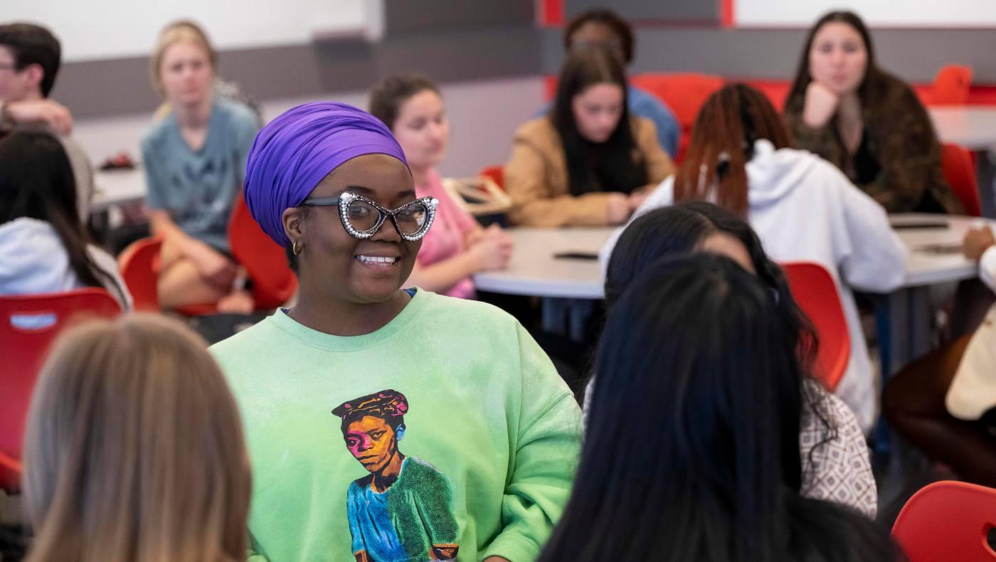 student smiles at table discussion