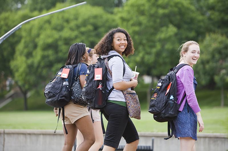 female students with backpacks smiling