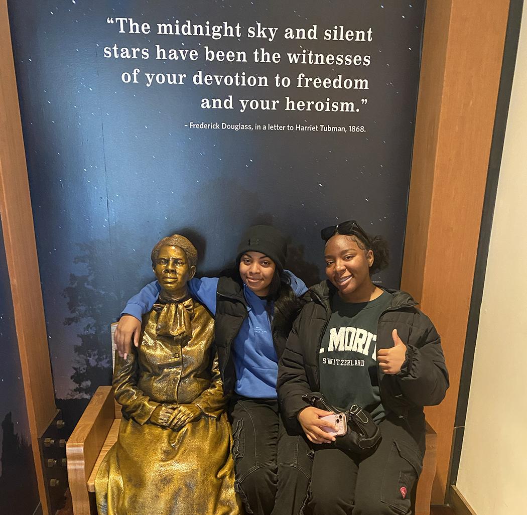 students with harriet tubman statue and a quote over their heads