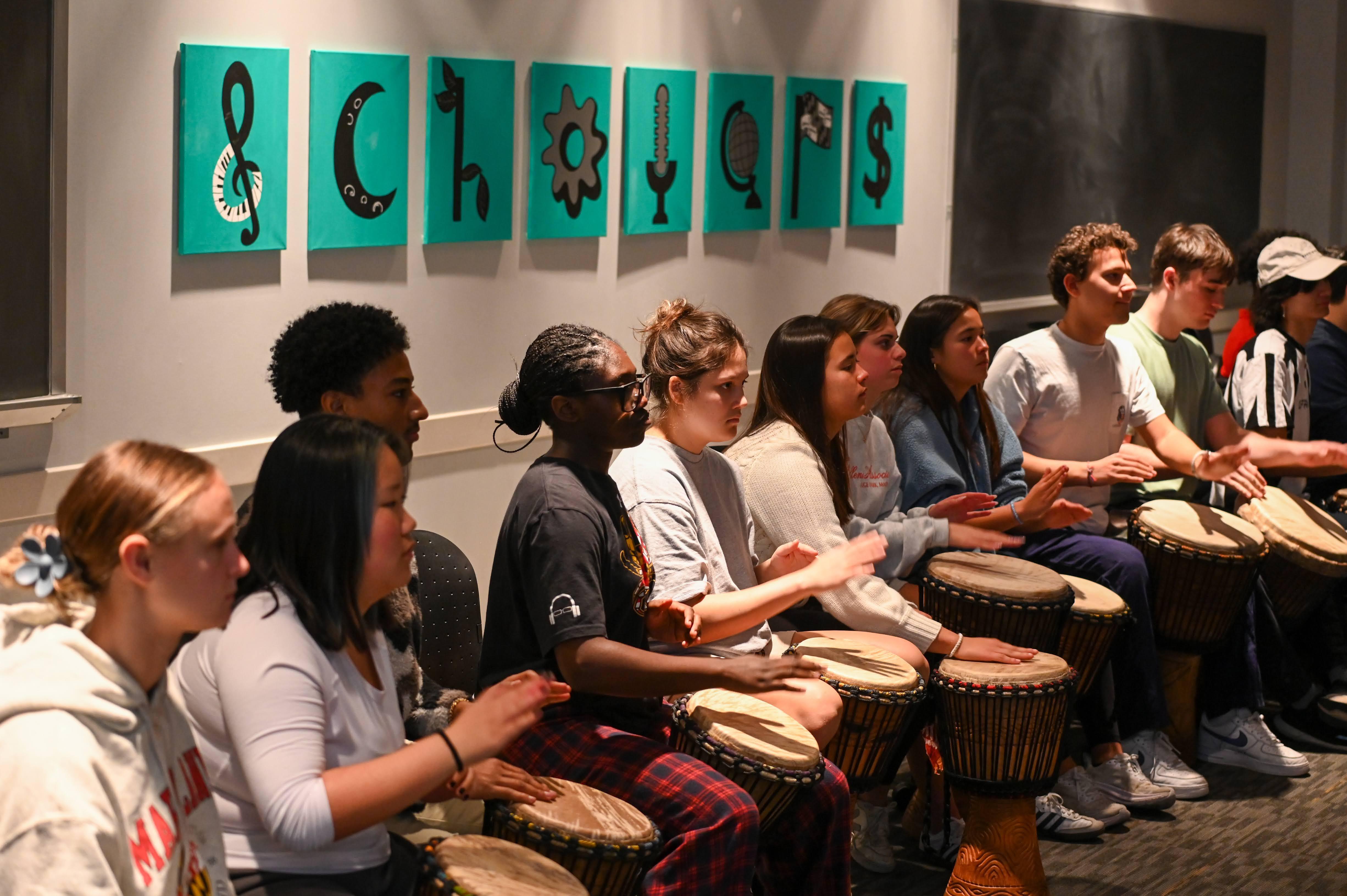 students seated playing drums with hands