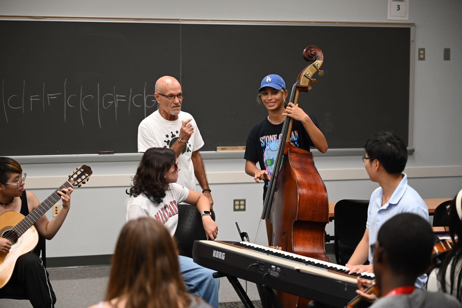 male music instructor with students holding various instruments