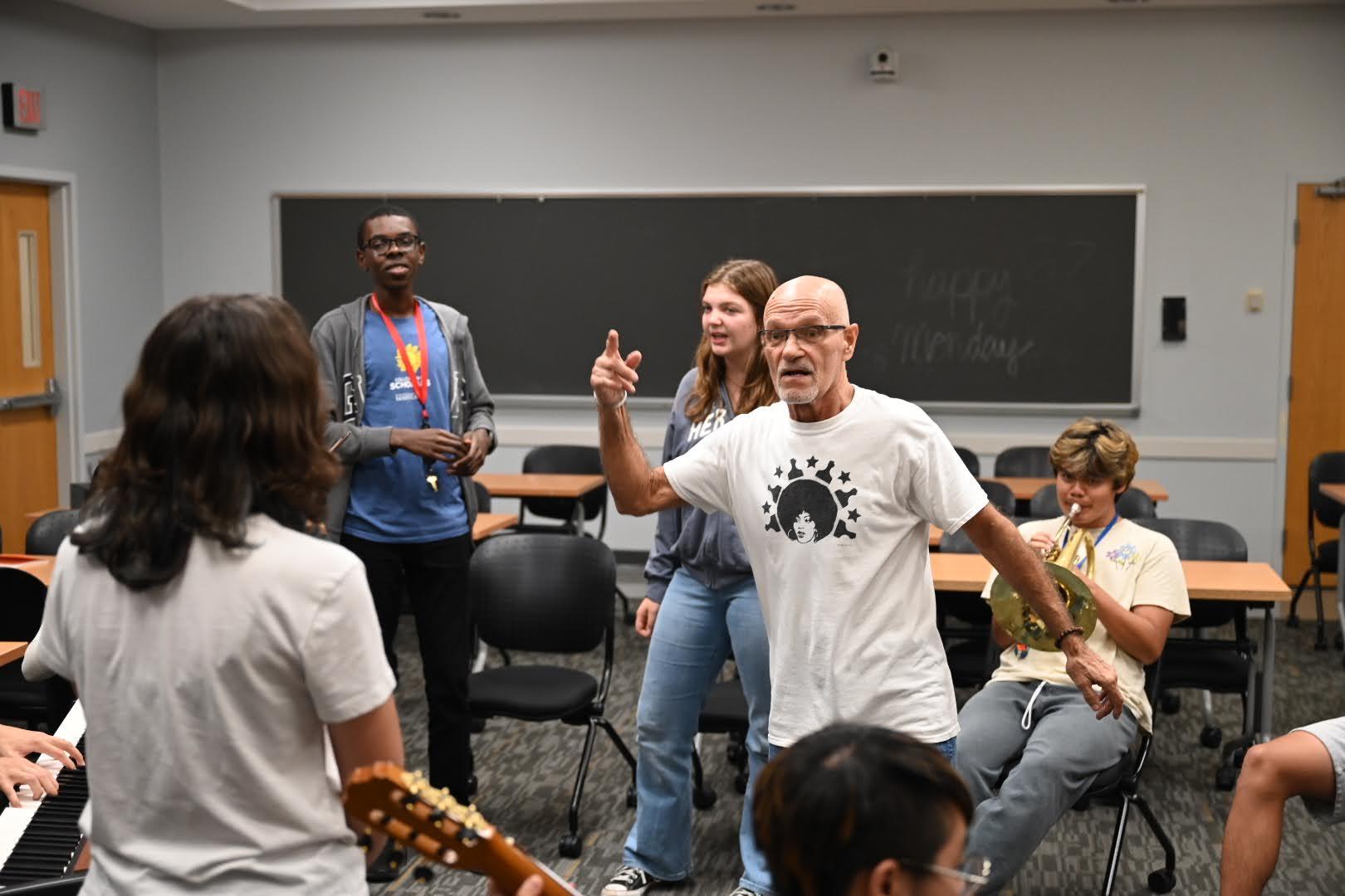 male music instructor with students holding various instruments