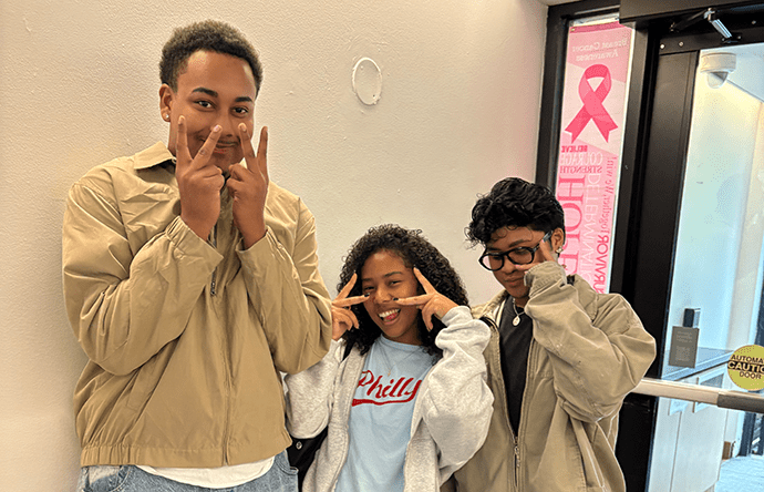 students smiling with peace signs in front of their faces