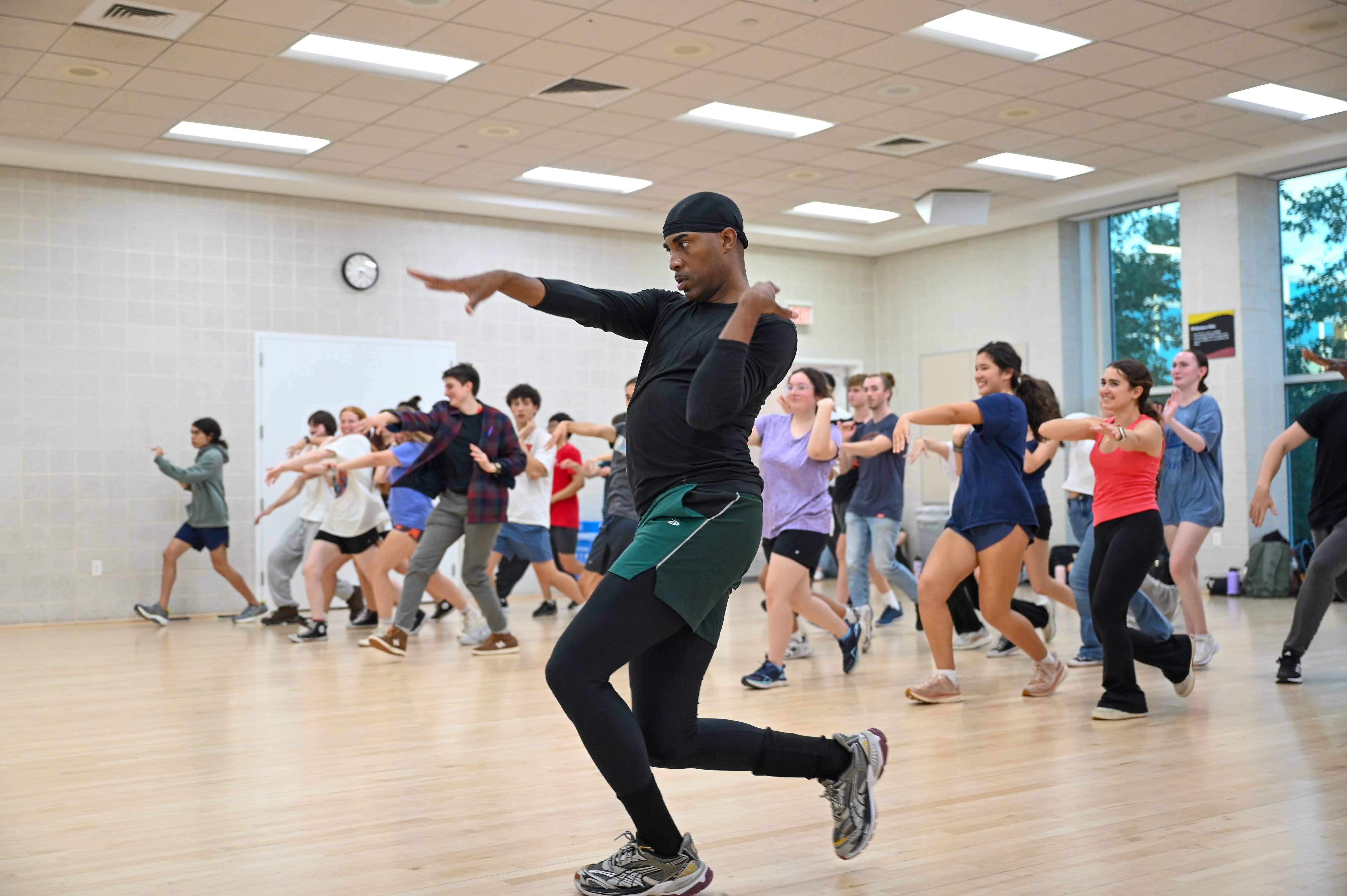 male dance instructor leading class of students