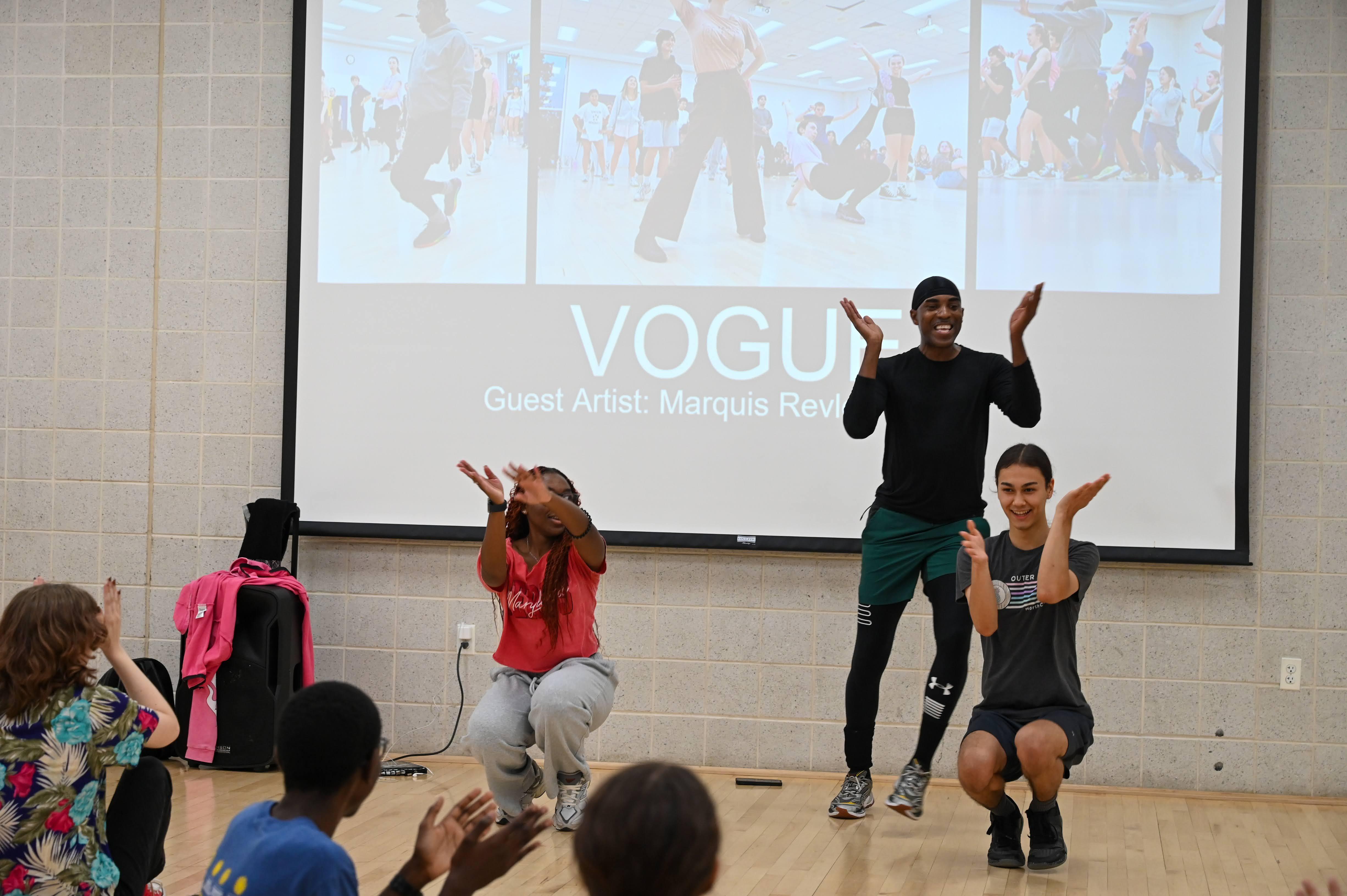 male dance instructor standing behind students practicing dance moves