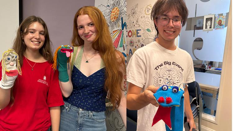 three students holding handmade sock puppets
