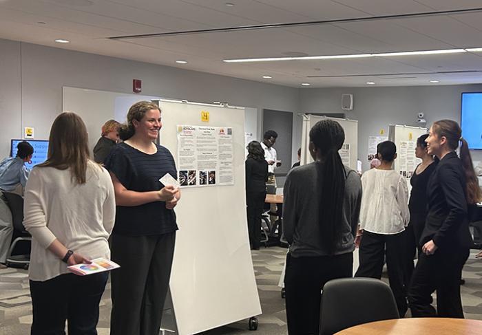 students standing around a poster board
