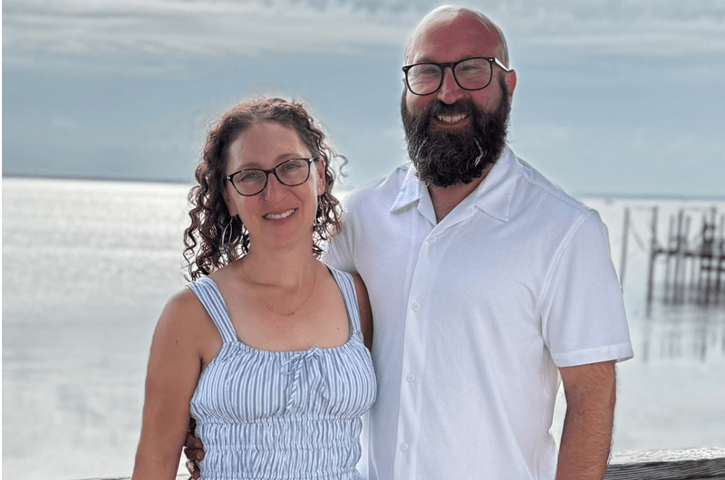 melissa and hart rossman stand in front of a body of water