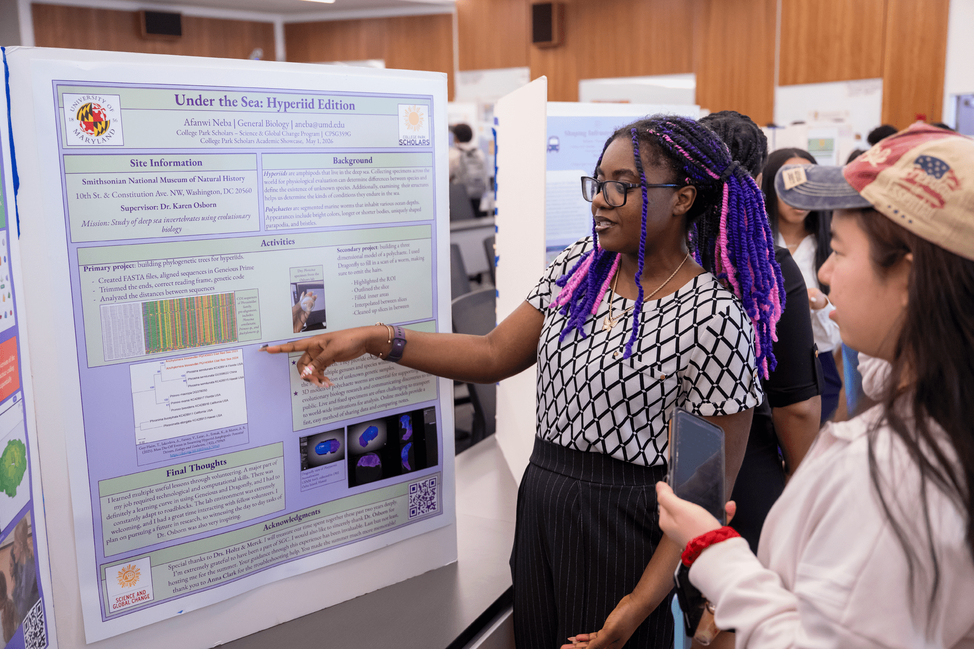 woman pointing at poster board with a student looking on