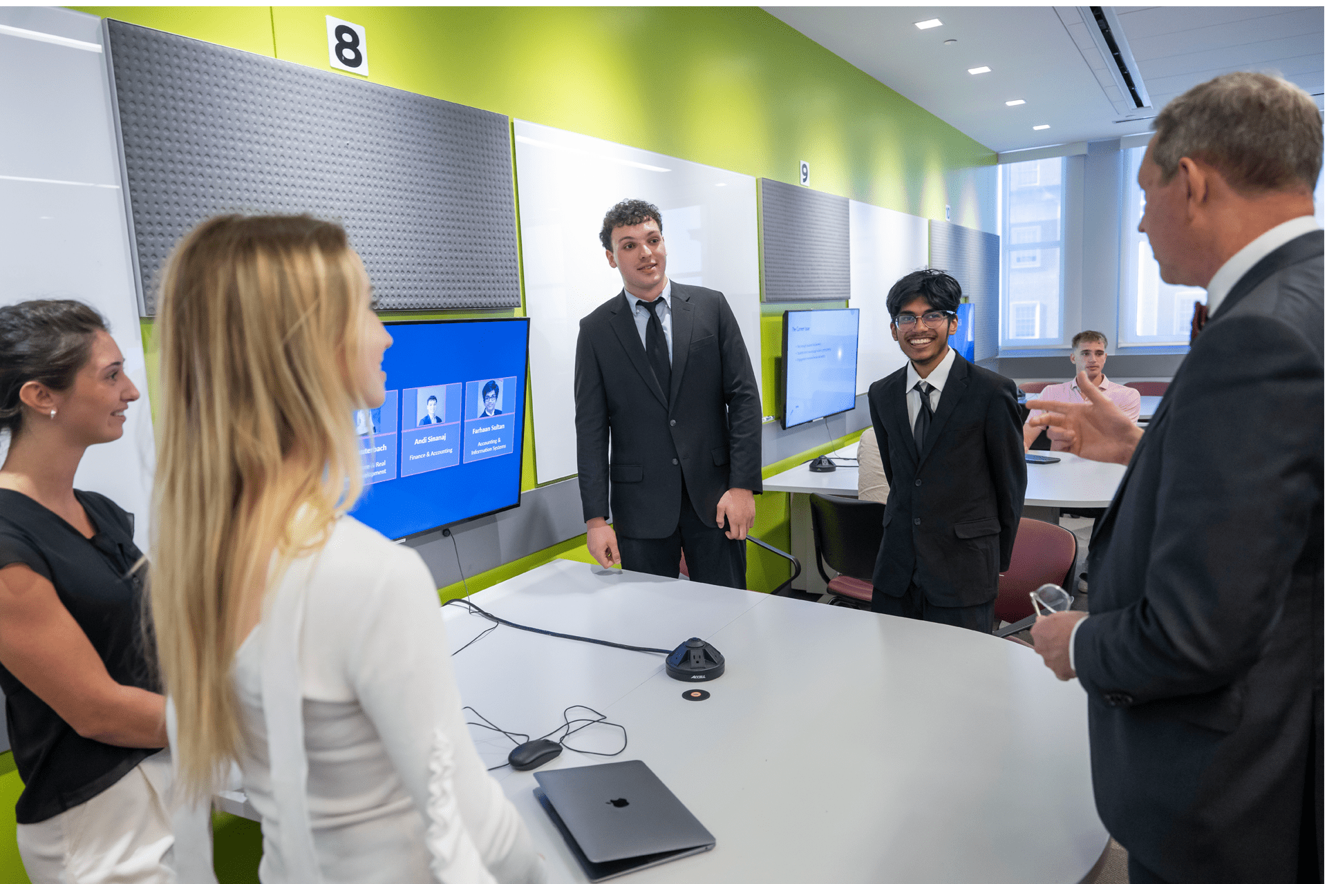 students standing around a table with a large screen