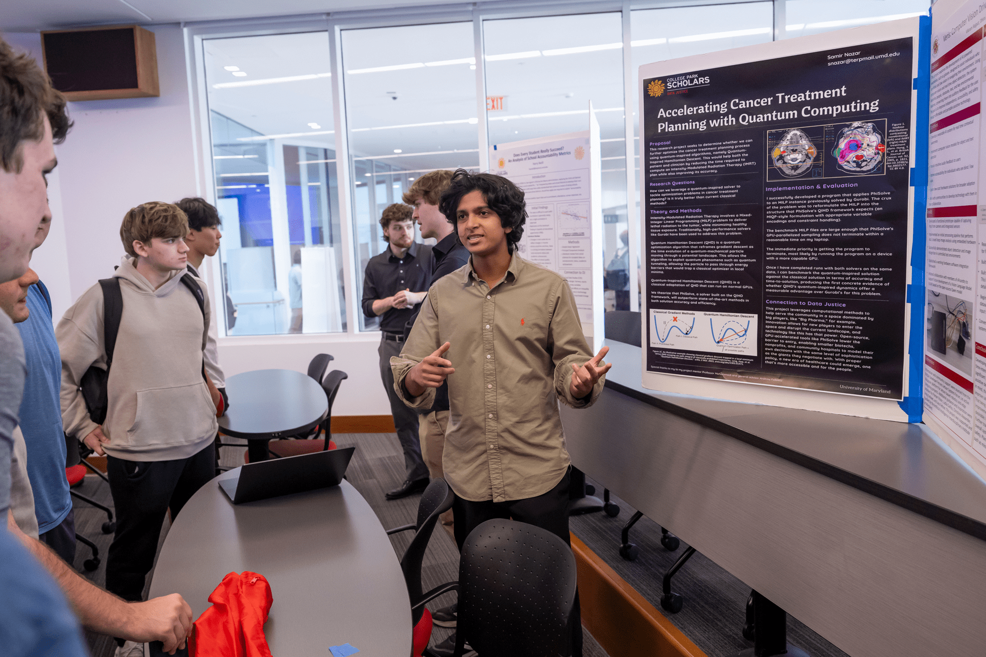 student smiling in front of poster with other students